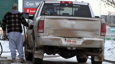 A motorist fuels up at a gas station in Edmonton, Alta.