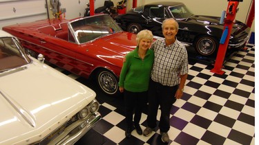Carol and Bob Vernon with their car collection which includes a red 1966 Thunderbird convertible.