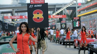 Grid girls stand next to vintage cars