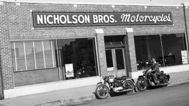 In the post-war era, Nicholson Bros. Motorcycles built a modern facility in downtown Saskatoon, Saskatchewan. Here, Lawrence Nicholson sits astride an Ariel Square Four with Bernie Nicholson's Triumph T100 in front.