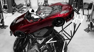 Tesla car next to the fairing of a Falcon Heavy rocket