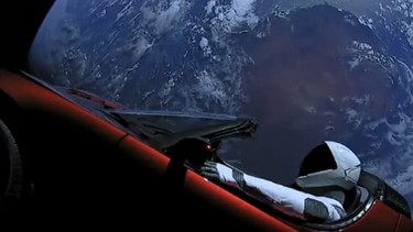 Tesla Roadster floating in space above the earth