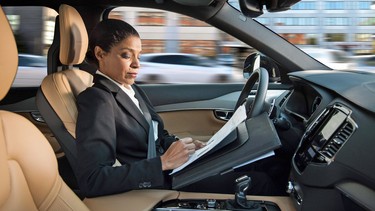 A woman reading inside an autonomous driving Volvo.