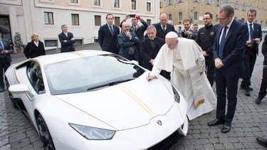 Pope Francis signing the hood of a Lamborghini Huracan gifted to him by the company.