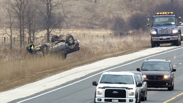 Ontario Provincial Police attend a crash on Hwy 402 west of Carriage Road near Delaware, Ont. on Wednesday March 28, 2018. A pick-up truck rolled several times before coming to a rest beside the highway.
