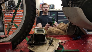 Ryan Schan takes a break from his bikes to sip a cold Steamwhistle, put up his feet and ponder his next move in his garage workshop.