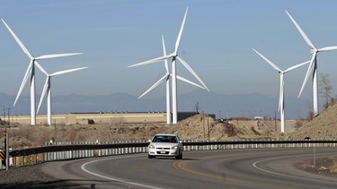 A car makes it's way up U.S. Highway 6 as several 2.1 mega watt  wind powered turbines owned by Edison Mission Energy,  sit a the mouth of Spanish Fork Canyon.