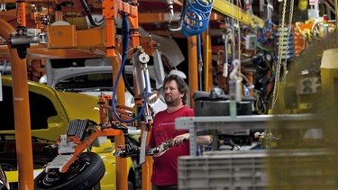 An assembly line worker at the General Motors Assembly plant in Oshawa works on a car on Friday, December 16, 2011.