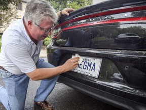 Ryk Edelstein wipes the vanity licence plate on his Dodge Charger at his home in Montreal Tuesday August 28, 2018.
