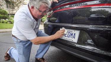 Ryk Edelstein wipes the vanity licence plate on his Dodge Charger at his home in Montreal Tuesday August 28, 2018.
