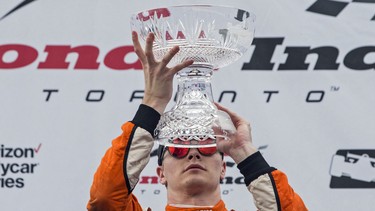 Josef Newgarden lifts a vase on the podium after winning the Honda Indy Toronto in Toronto on Sunday, July 16, 2017.
