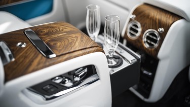 A pair of champagne flutes in the back of a Rolls-Royce Cullinan SUV.