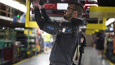 A Ford assembly line worker using one of the company's new Ekso vests to assist with lifting and other tasks.
