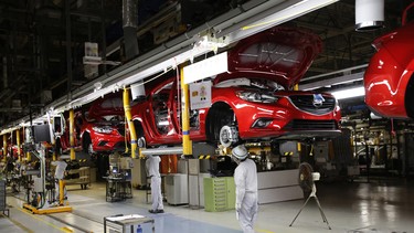 In this 2013 file photo, Mazda employees work on the assembly line of the Mazda6 (Atenza) model at its plant in Hofu, Yamaguchi prefecture, southwestern Japan.