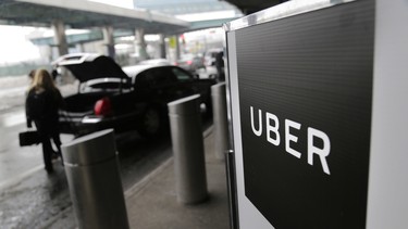 In this March 15, 2017 file photo, a sign marks a pick-up point for the Uber car service at LaGuardia Airport in New York.