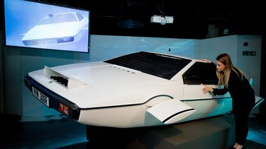 A woman poses with "Wet Nellie" from the James Bond film "The Spy Who Loved Me" at the press preview for the exhibition "Bond in Motion" at the London Film Museum in central London on March 18, 2014.