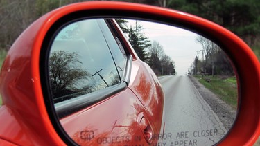 A convex passenger-side mirror with warning.