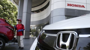 FILE - In this July 31, 2018, file photo, an employee of Honda Motor Co. cleans a Honda car displayed at its headquarters in Tokyo. Japanese automaker Honda Motor Co. is reporting Tuesday, Oct. 30, 2018, a 21 percent jump in fiscal second quarter profit on cost cuts and healthy motorcycle sales.