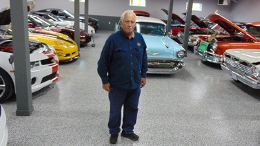 Garry Cassidy in the newly-rebuilt shop with some of the collector cars replacing those lost in last year’s fire.