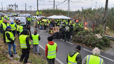 Protesters block a road during a demonstration as part of the so-called "yellow vest" (Gilets Jaunes in French) movement to protest against high fuel prices on November 19, 2018 near the oil depot of Frontignan, southern France.