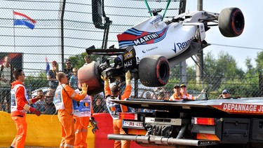 Race marshalls lift Williams' Brazilian driver Felipe Massa's car after he crashed during the first practice session at the Spa-Francorchamps circuit in Spa on August 25, 2017 ahead of the Belgian Formula One Grand Prix.