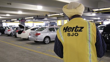 In this May 9, 2011 file photo, a Hertz rental car worker checks out cars at San Jose International Airport in San Jose, Calif.