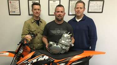 BRC Engineering’s Steve Buffel, left, Riley Will, middle, and his brother Carter Will with the BRC 500cc two-stroke engine that slots into a stock 2007 - 2016 KTM dirt bike chassis.