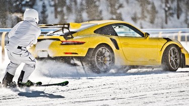An athlete Skijoring behind a Porsche GT2 RS