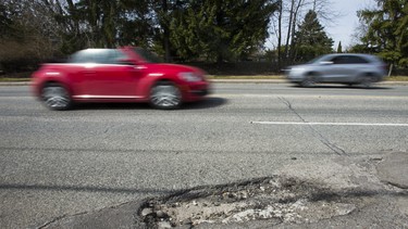 This file photo shows a pothole on Bayview Ave., north of Moore Ave. in Toronto, Ont. on Monday April 10, 2017. Can't stand potholes? Blame global warming.