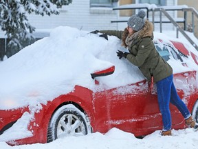 In this file photo, Ale Veffer clears snow from her Hyundai in Calgary on Dec. 20, 2017, after a winter storm left over 20 centimetres of snow in parts of the city. Don't want to subject your car o this? A winter beater is an option, but there are few things to consider first.