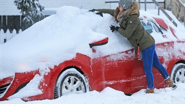 In this file photo, Ale Veffer clears snow from her Hyundai in Calgary on Dec. 20, 2017, after a winter storm left over 20 centimetres of snow in parts of the city. Don't want to subject your car o this? A winter beater is an option, but there are few things to consider first.
