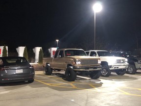 Trucks owned by a group of young men in North Carolina block a row of Tesla Superchargers