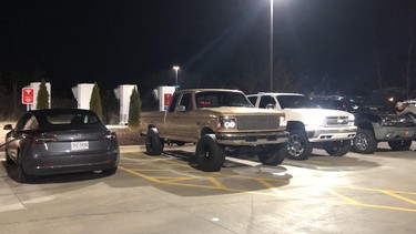 Trucks owned by a group of young men in North Carolina block a row of Tesla Superchargers