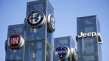 In this file photo taken on August 21, 2017,  a car dealer in Turin, Italy, shows the logos of Jeep, Fiat, Lancia and Alfa Romeo automobile company, brands of Fiat Chrysler Automobiles (FCA).