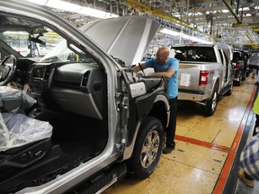 In this Sept. 27, 2018, file photo a United Auto Workers assemblyman works on a 2018 Ford F-150 truck being assembled at the Ford Rouge assembly plant in Dearborn, Michigan.