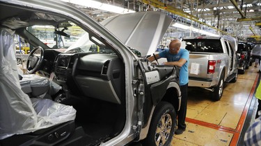 In this Sept. 27, 2018, file photo a United Auto Workers assemblyman works on a 2018 Ford F-150 truck being assembled at the Ford Rouge assembly plant in Dearborn, Michigan.
