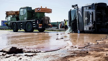Tons of liquid milk chocolate are spilled and block six lanes on a highway after a truck transporting it overturned near Slupca, in western Poland, on Wednesday, May 9, 2018.