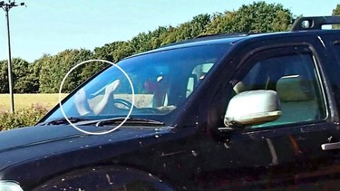 A U.K. driver with his feet on the dashboard of his car.