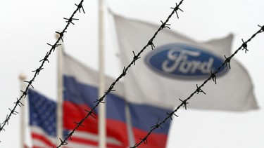 In this file photo taken on February 14, 2007 three flags are seen behind a barbed wire of the Ford motor company during the 24-hour strike in Vsevolozhsk, northwestern Russia close to Saint Petersburg.