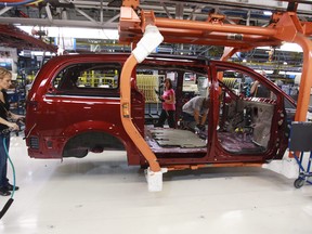 Workers on the production line at Chrysler's assembly plant in Windsor, Ont., work on one of their new minivans on January 18, 2011.