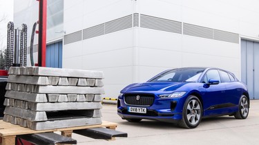 A Jaguar I-Pace next to a pallet of recycled aluminum