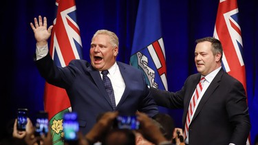 Ontario Premier Doug Ford, left, and United Conservative Leader Jason Kenney greet supporters on stage an anti-carbon tax rally in Calgary, Friday, Oct. 5, 2018.