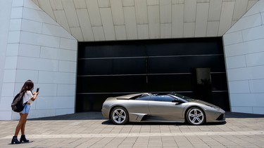 A woman takes a snapshot of a seized Lamborghini that will be auctioned taken at Los Pinos former presidential residence in Mexico City, on May 21, 2019.