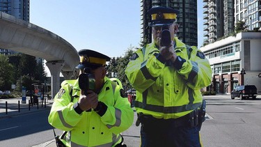 A Coquitlam RCMP officer, left, poses next to a life-sized, metal poster-board of an RCMP officer, in this undated handout photo.