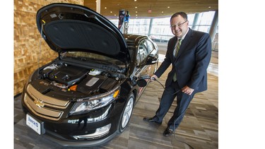 Blair Qualey, president and CEO of the New Car Dealers Association of B.C., plugs in a Chevrolet Volt at the Vancouver International Auto Show.