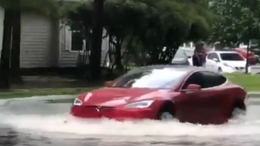 Tesla Model S drives through flooded street