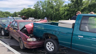 A '90s Nissan Sentra sandwiched in a collision between two '90s Nissan Hardbody trucks
