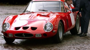 Simon Kidston, of Bonham and Brooks auction house, peers inside a vintage 1963 Ferrari 250 GTO which won the 1963 Le Mans GT race, in London, 30 October 2000.