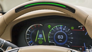 A steering wheel light bar and cluster icons indicates the status of Super Cruise™ and will prompt the driver to return their attention to the road ahead if the system detects driver attention has turned away from the road too long. Super Cruise is active (green light bar) in this image.