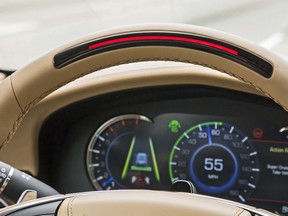 A steering wheel light bar and cluster icons indicates the status of Super Cruise™ and will prompt the driver to return their attention to the road ahead if the system detects driver attention has turned away from the road too long. Super Cruise is asking for the driver to resume control of steering (flashing red light bar) in this image.